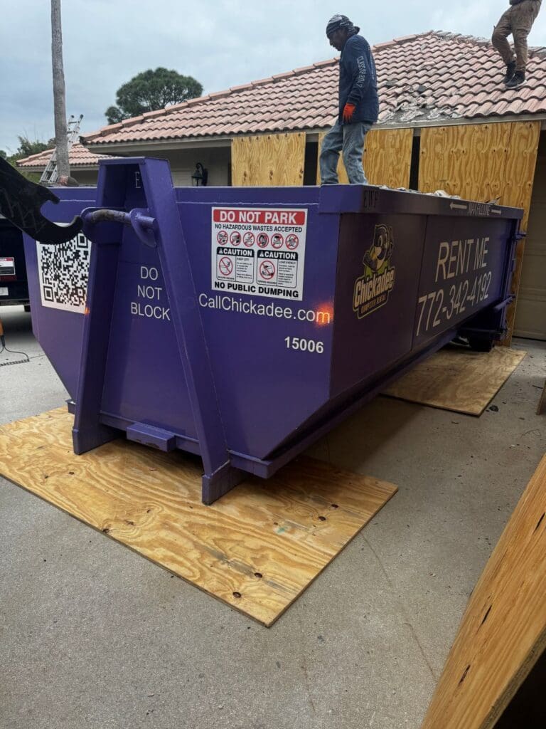 Tile roof tear-off debris being loaded into a Chickadee dumpster in PGA Village, Port St. Lucie