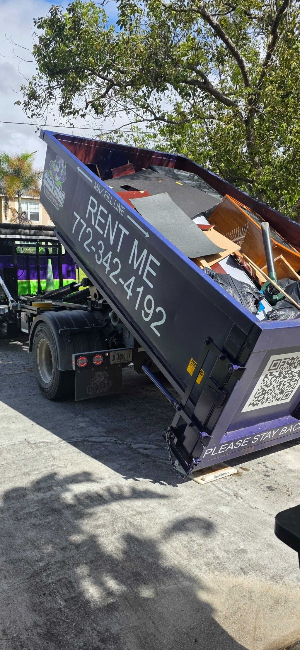 dumpster rental delivery in driveway with roll off container for home cleanout on the Treasure Coast